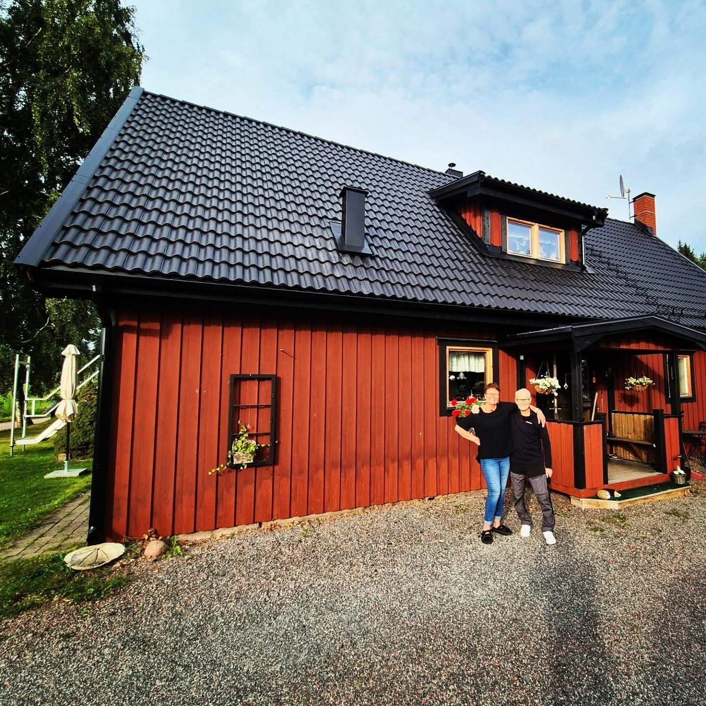 Nöjda kunder framför sitt nya svarta tegeltak