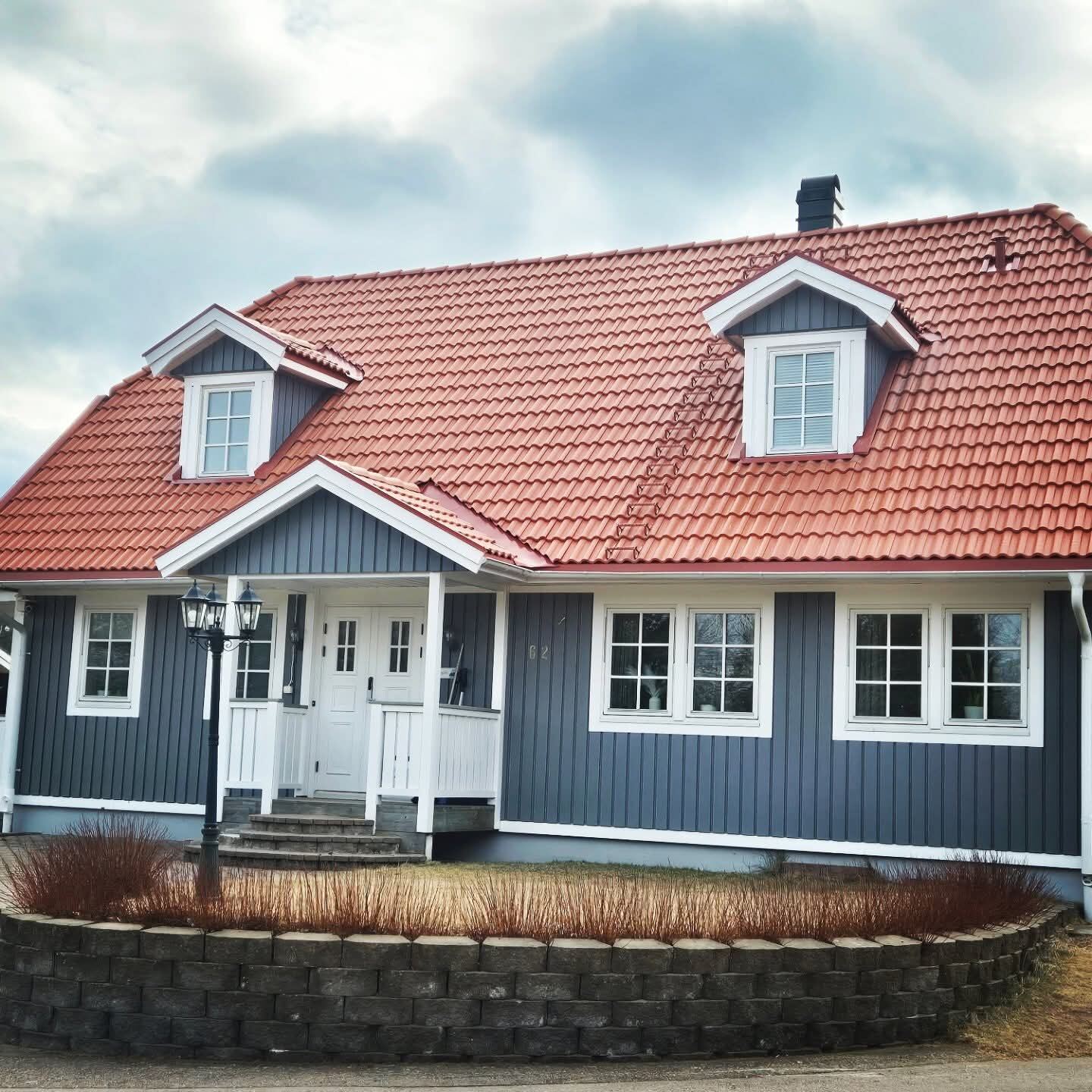 Rött tegeltak på blågrått hus, framifrån