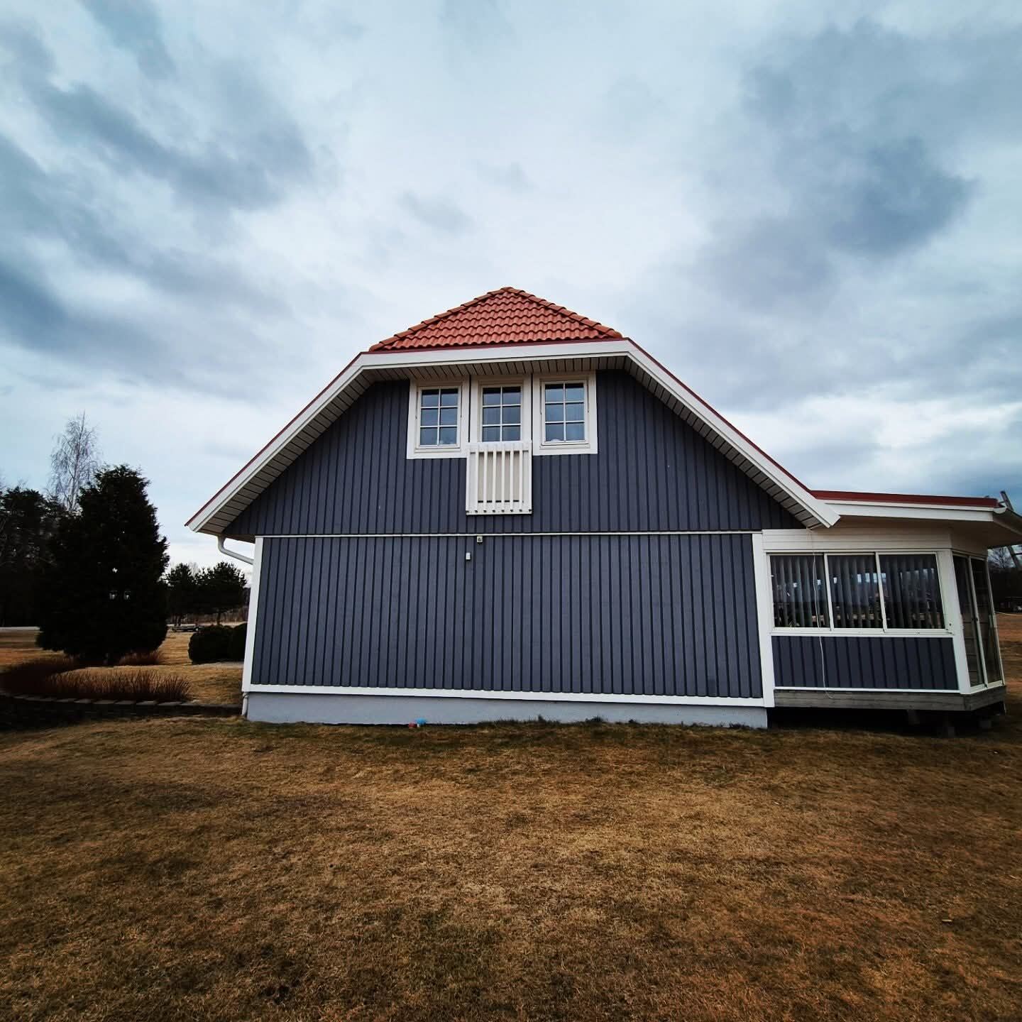 Valmat rött tak på blågrått hus