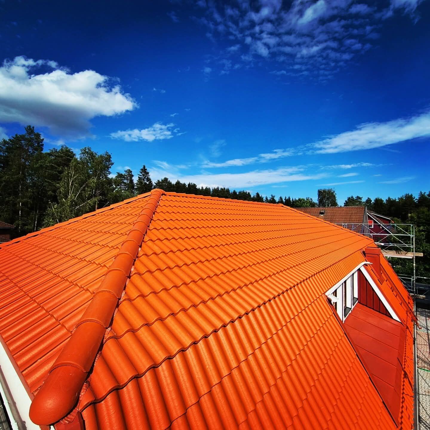 Nytt orange tegeltak, ren linje mot blå himmel
